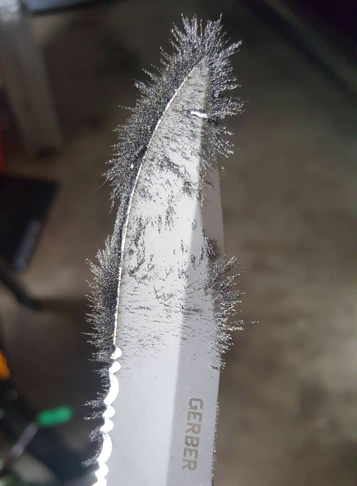 Namagnesowane opiłki metalu na krawędzi noża