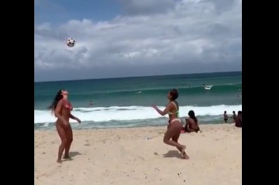 Dwie fajne dziewczyny na plaży pokazują jak się bawić piłką