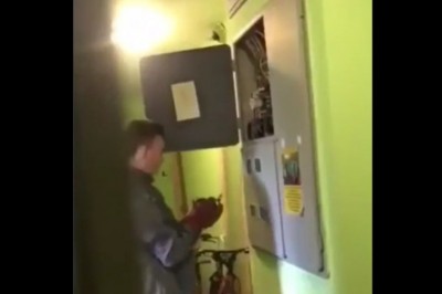 Amator elektryk grzebie w skrzynce na klatce schodowej