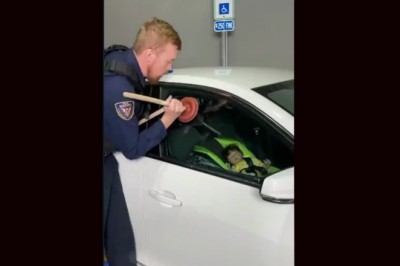 Policjant pokazuje w jaki sposób można otworzyć drzwi w aucie